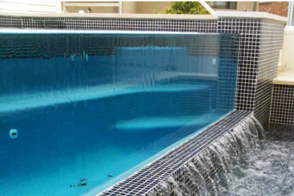 Pool water cascading over glass